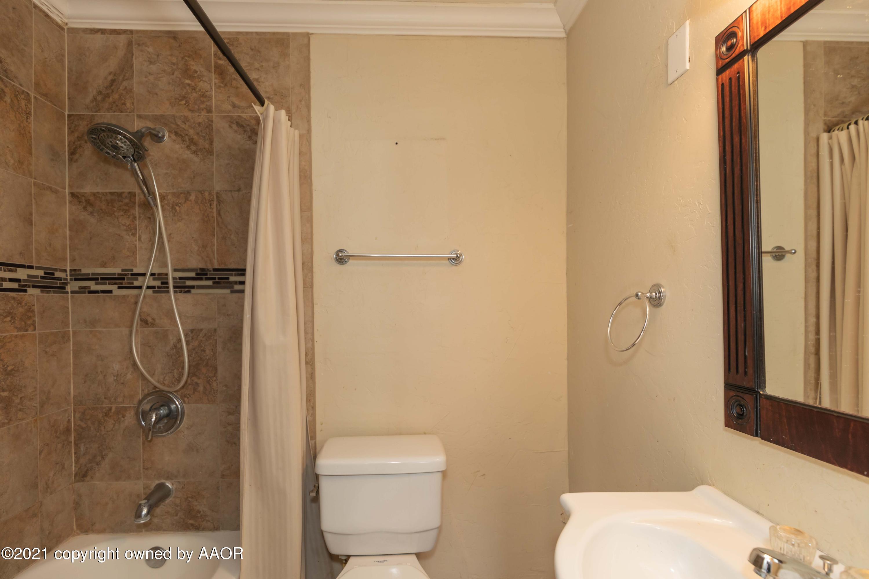 5102 South Travis Street Amarillo, TX 79110 - Photo 14 of 24 a bathroom with a shower a toilet and a sink