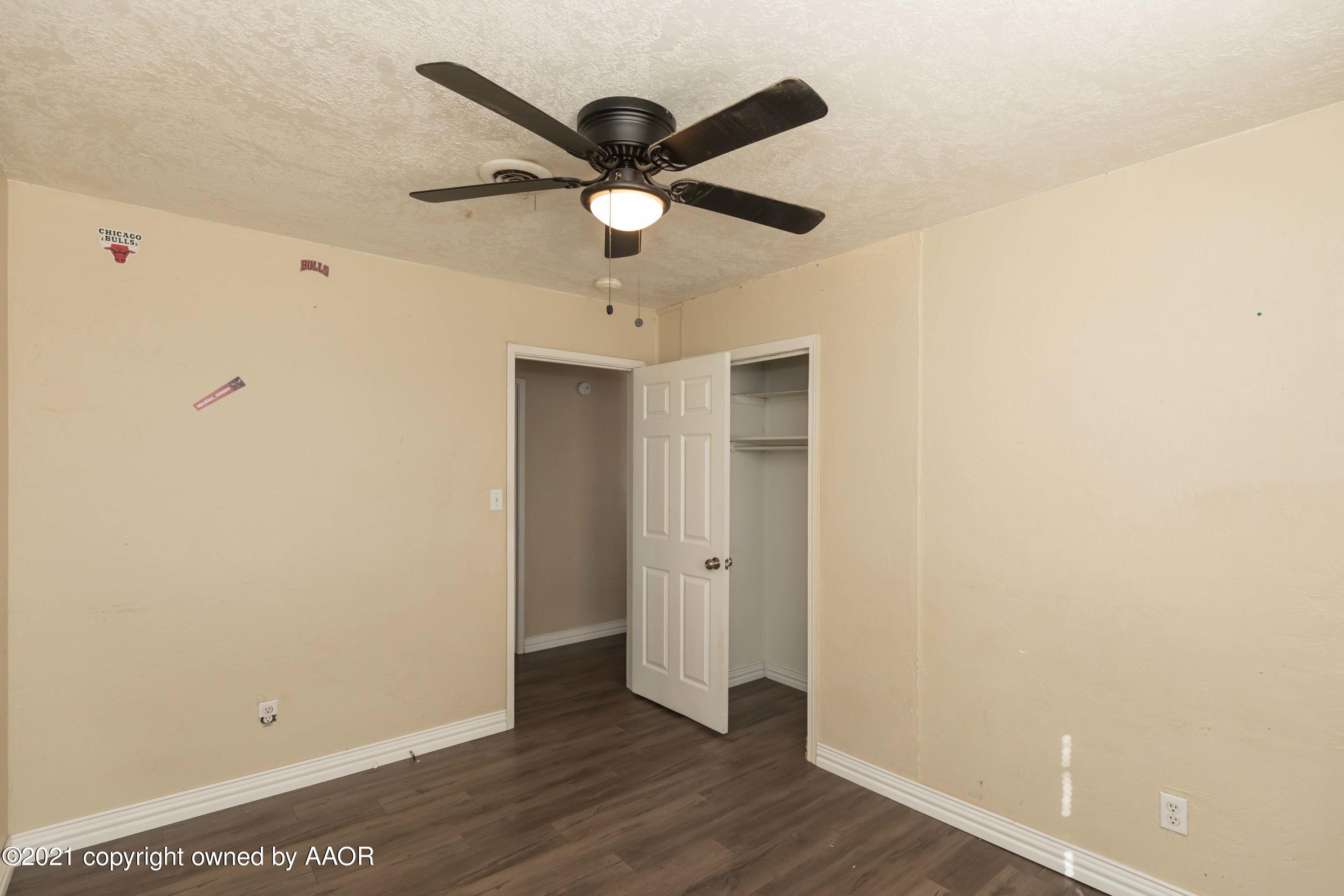 5102 South Travis Street Amarillo, TX 79110 - Photo 17 of 24 an empty room with wooden floor ceiling fan and carpet