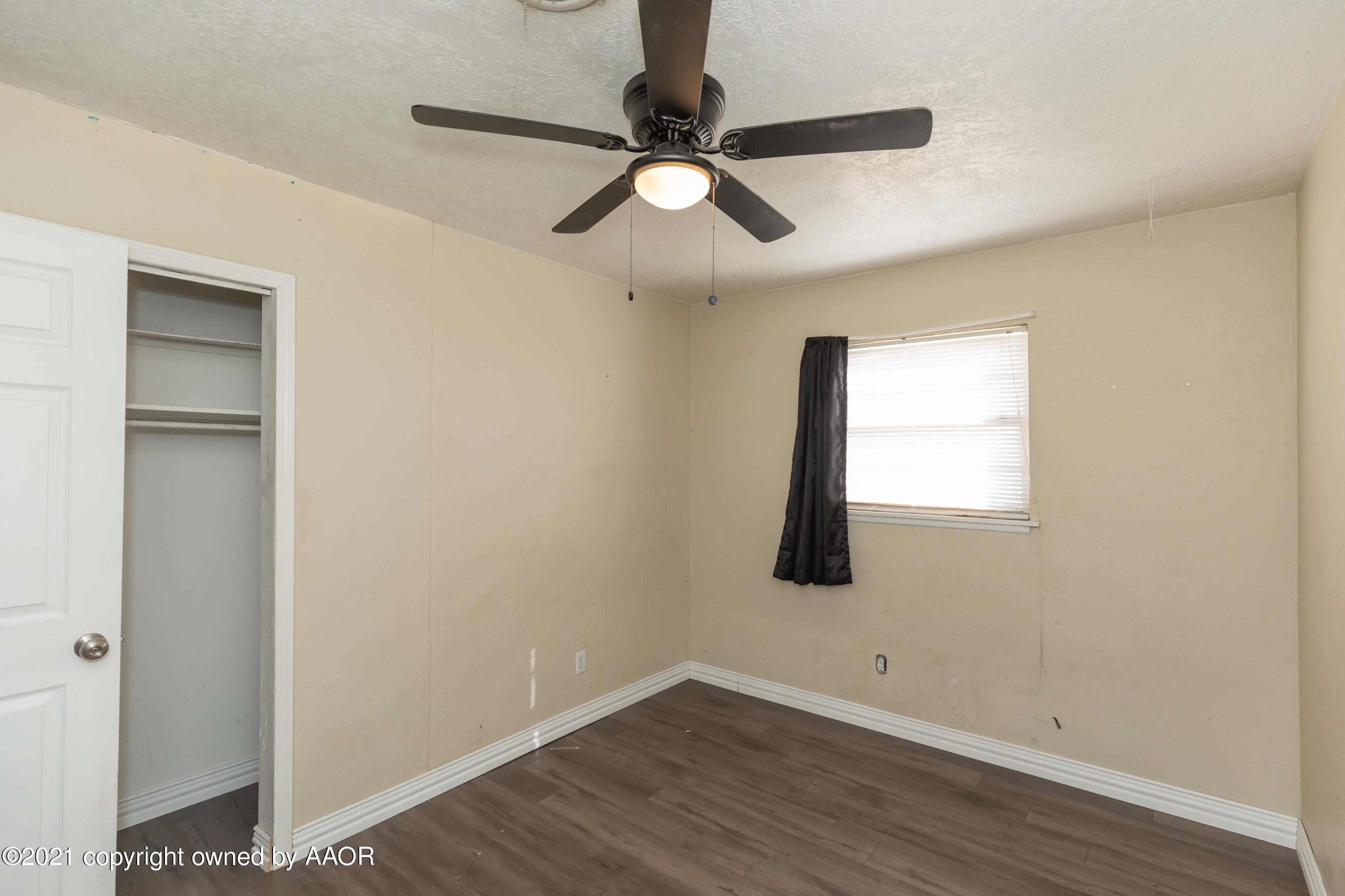 5102 South Travis Street Amarillo, TX 79110 - Photo 18 of 24 an empty room with wooden floor closet and windows