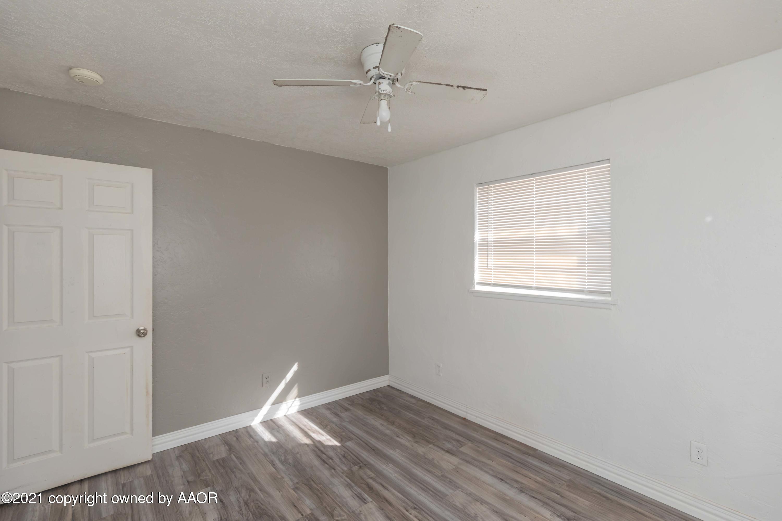5102 South Travis Street Amarillo, TX 79110 - Photo 19 of 24 an empty room with a window and a ceiling fan