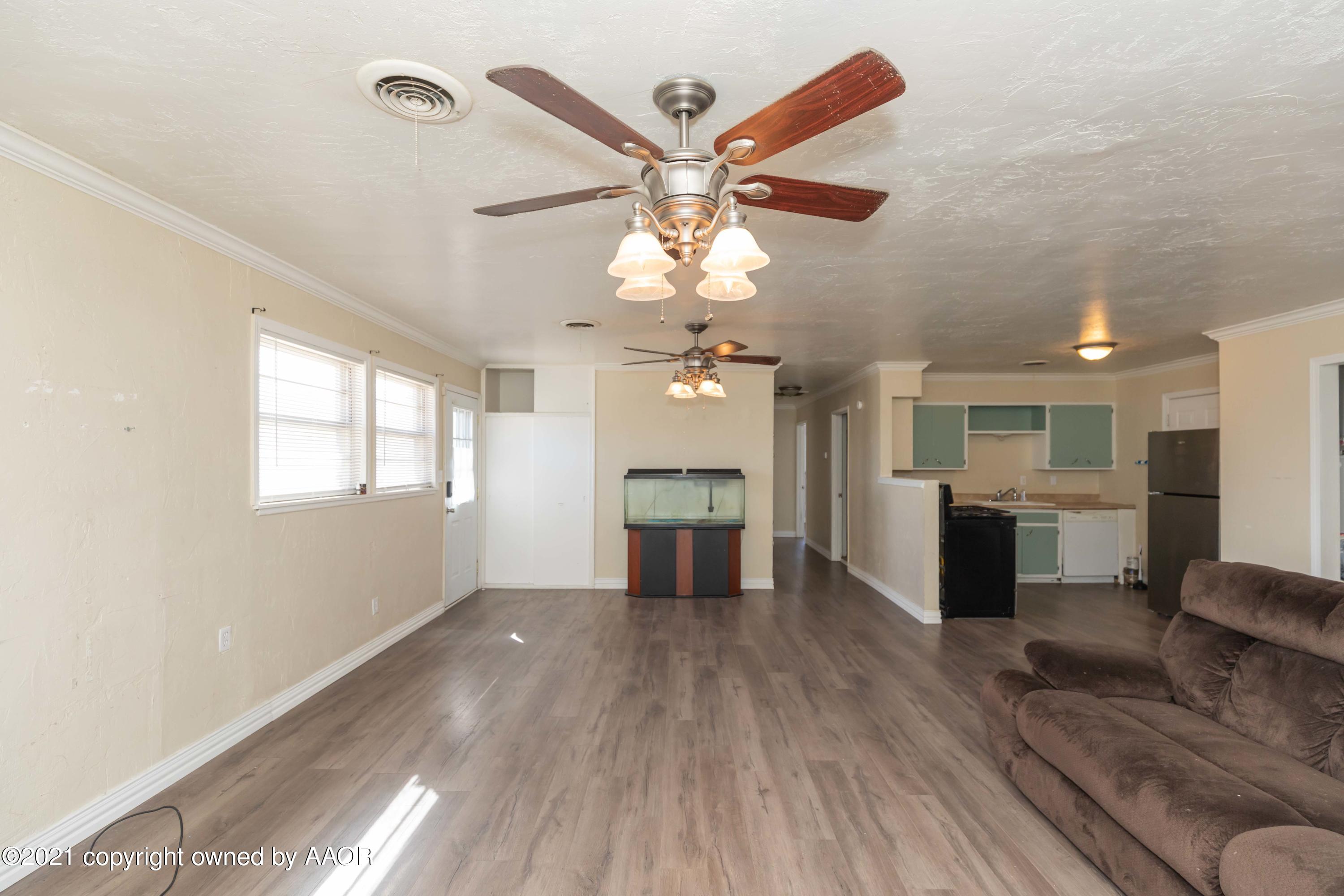 5102 South Travis Street Amarillo, TX 79110 - Photo 6 of 24 wooden floor in an empty room with a window