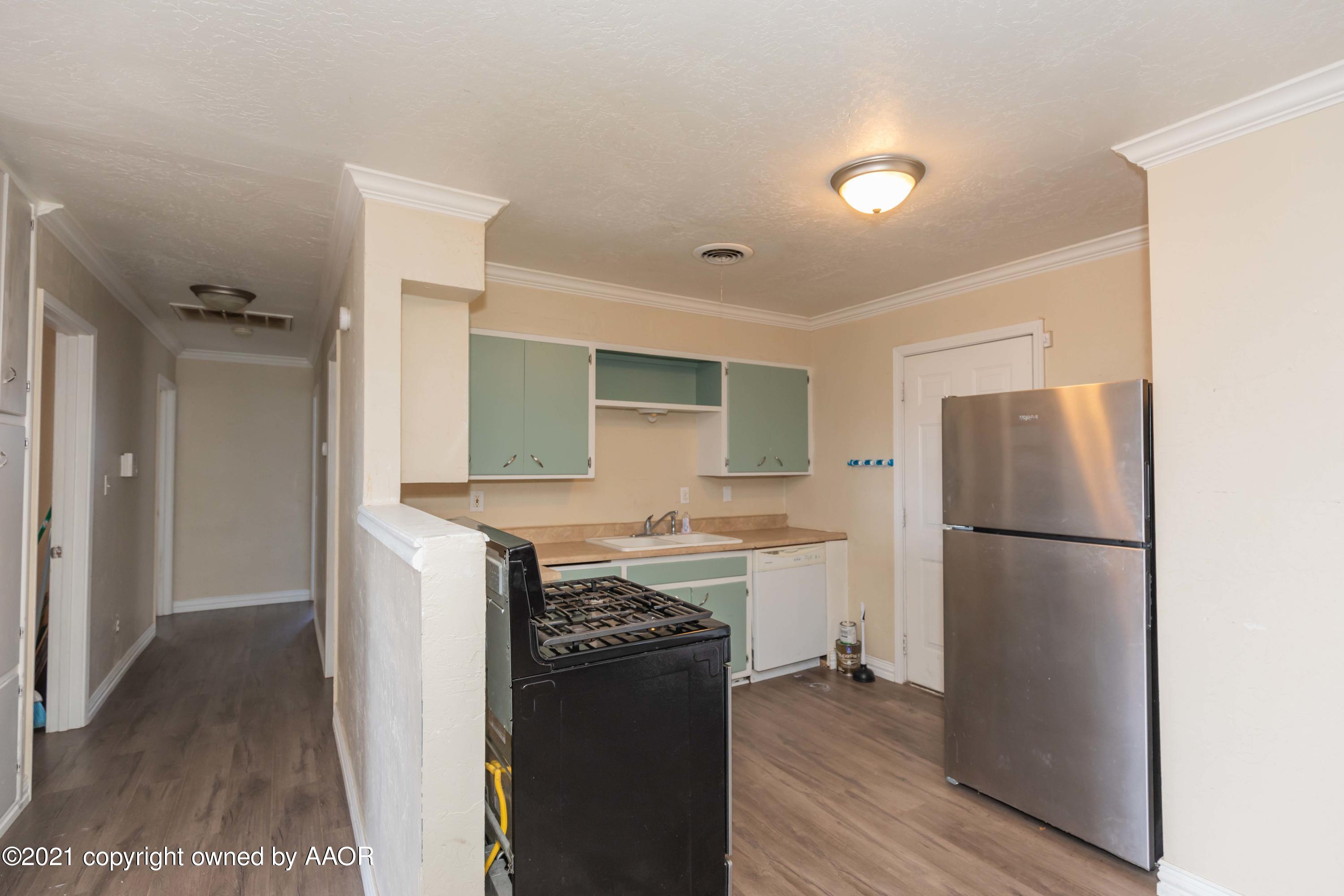 5102 South Travis Street Amarillo, TX 79110 - Photo 7 of 24 a kitchen with a refrigerator and a stove