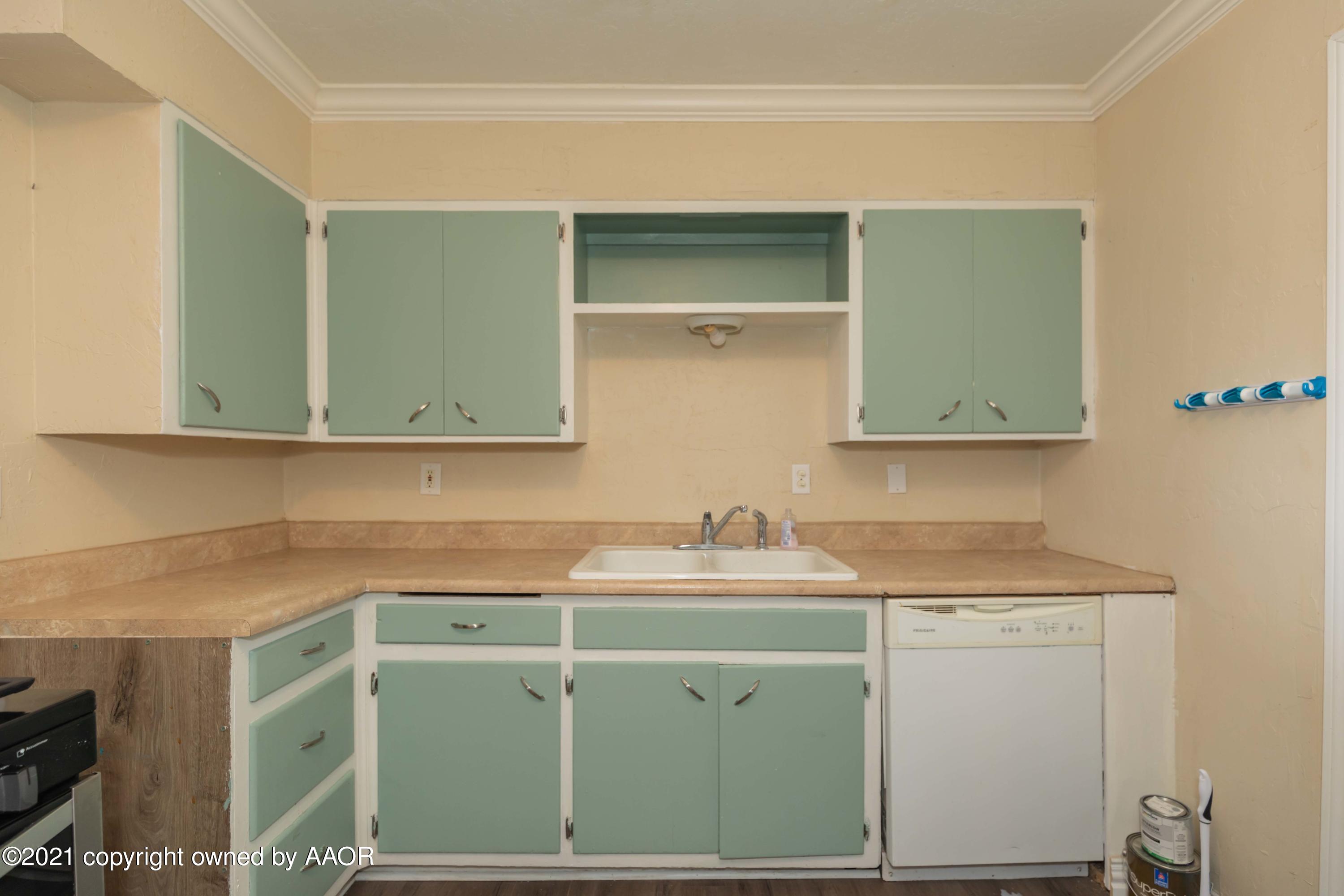 5102 South Travis Street Amarillo, TX 79110 - Photo 8 of 24 a utility room with a sink cabinets and wooden floor