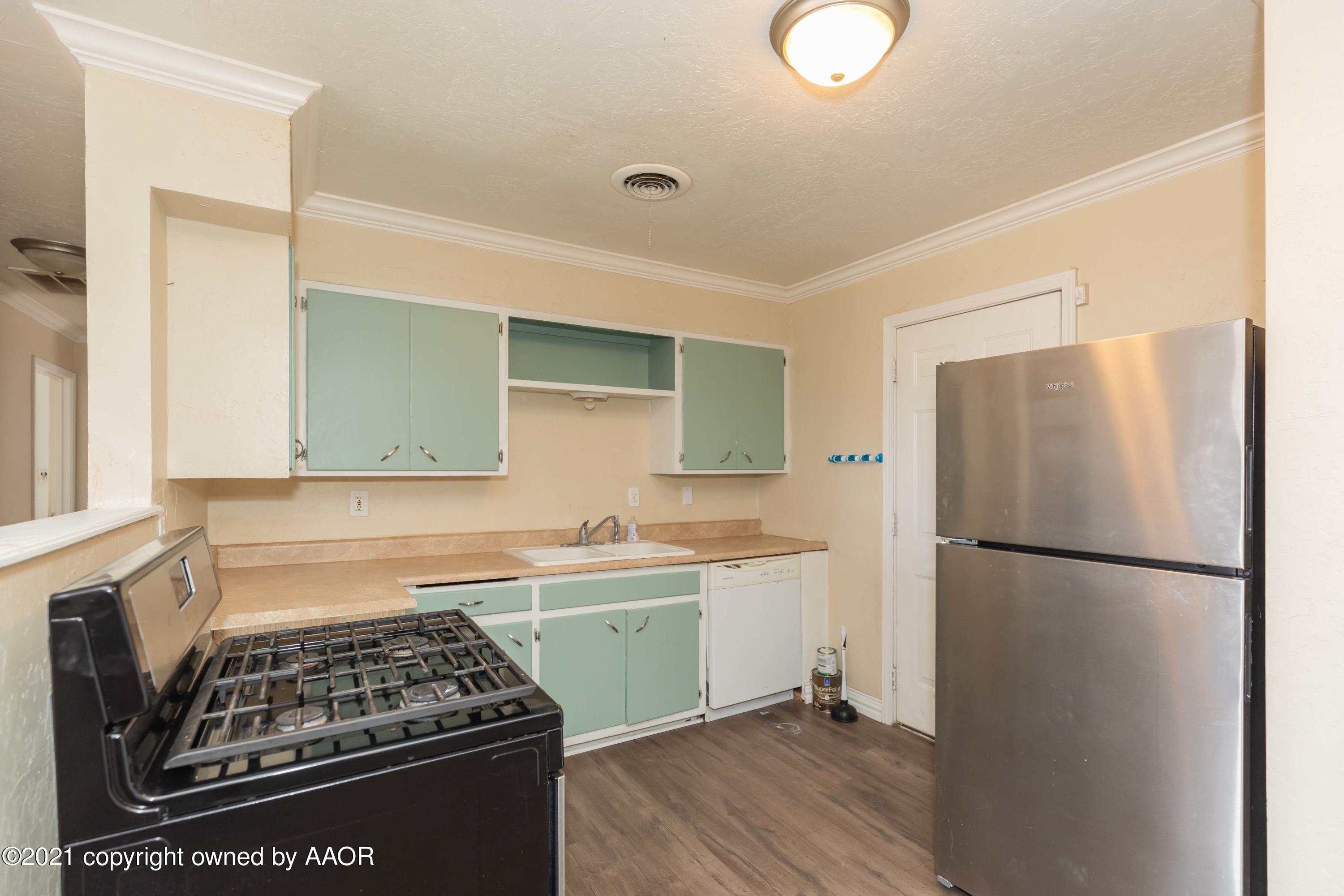 5102 South Travis Street Amarillo, TX 79110 - Photo 10 of 24 a kitchen with a refrigerator and a sink