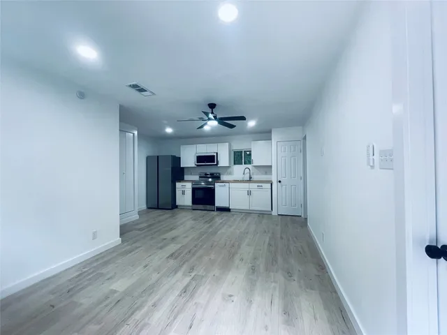 a kitchen with stainless steel appliances granite countertop a stove top oven a sink and a refrigerator