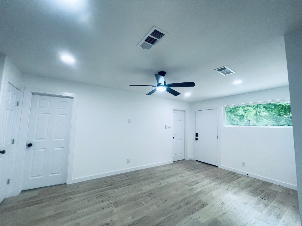 7107 Guadalupe Street, Unit C Austin, TX 78752 - Photo 4 of 7 an empty room with wooden floor and ceiling fan