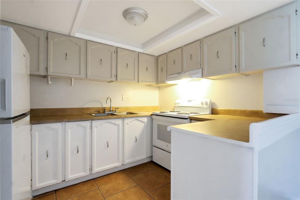 1902 Honour Road, Unit 11 Orlando, FL 32839 - Photo 6 of 18 a kitchen with granite countertop white cabinets and white appliances