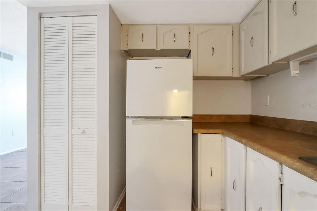 1902 Honour Road, Unit 11 Orlando, FL 32839 - Photo 7 of 18 a kitchen with a refrigerator and cabinets