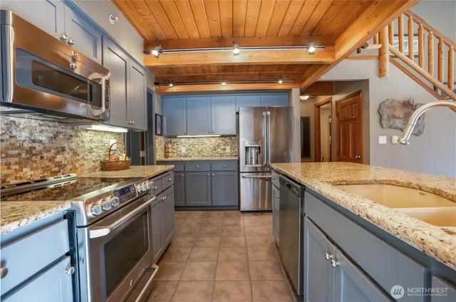 a large kitchen with kitchen island a sink stainless steel appliances and cabinets