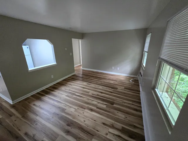 a view of room with window and wooden floor