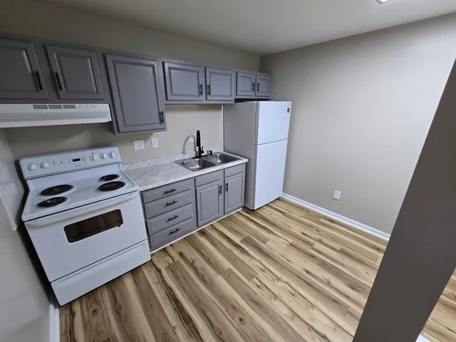 a kitchen with a stove and white cabinets