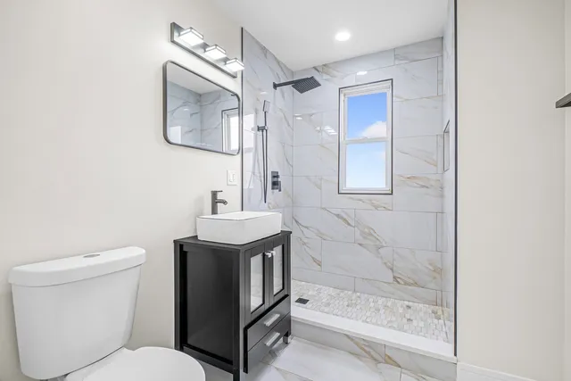 a bathroom with a sink a toilet and shower