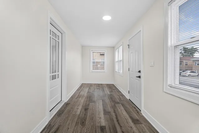 a view of a room with wooden floor and windows