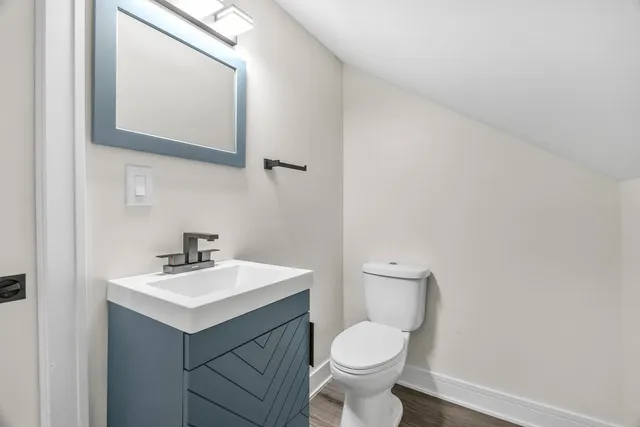 a bathroom with a toilet sink and mirror