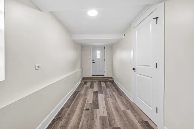 a living room with a table chairs and windows
