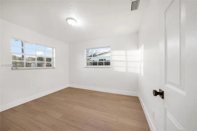 a view of a room with wooden floor and window