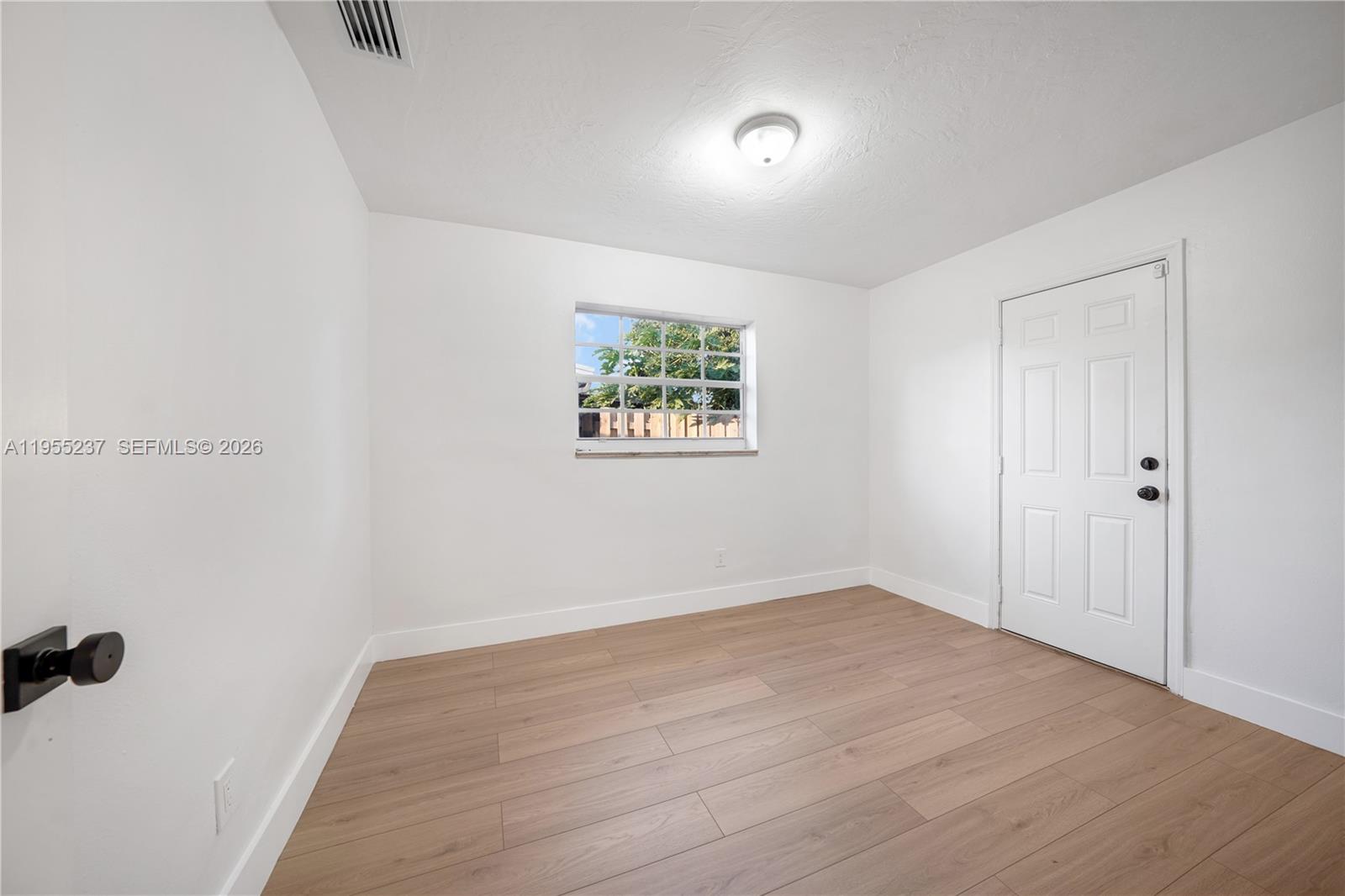 368 Southwest 64th Terrace Pompano Beach, FL 33068 - Photo 20 of 23 an empty room with wooden floor and windows