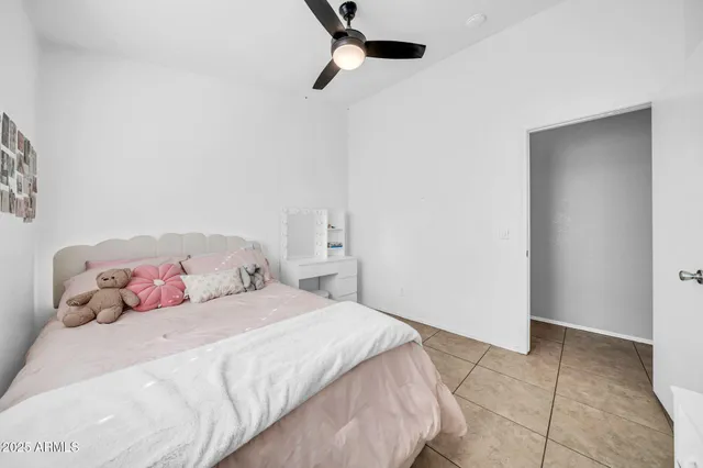 a bedroom with a bed and a ceiling fan