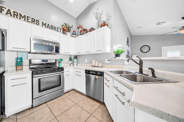 a kitchen with white cabinets sink and stainless steel appliances