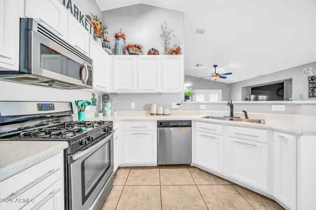 a kitchen with cabinets and steel appliances