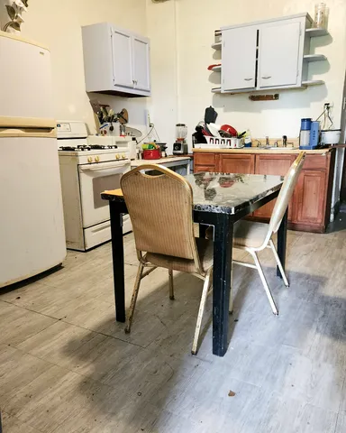 a kitchen with a table chairs stove and cabinets