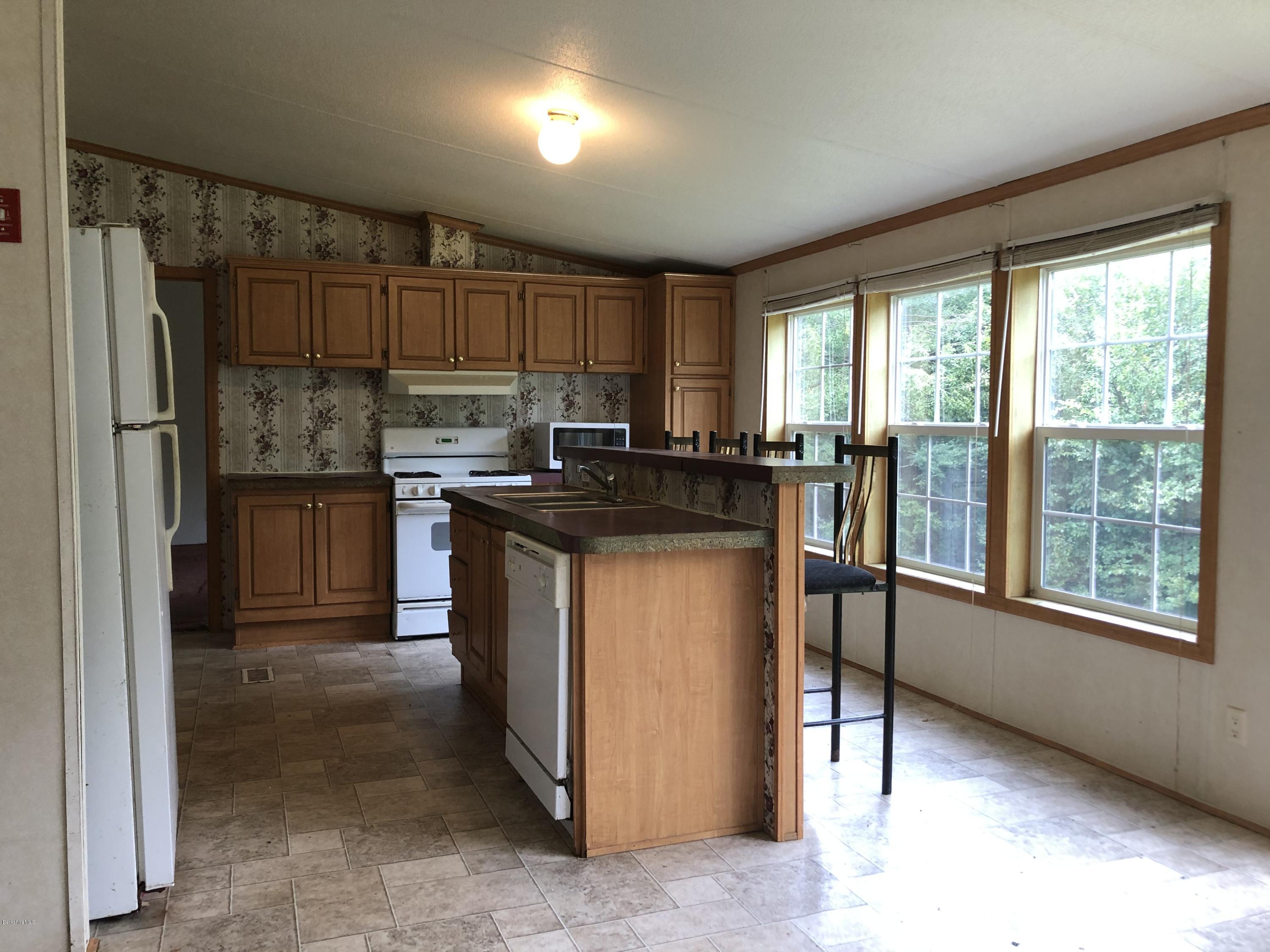 55 East Windsor Road Peru, MA 01235 - Photo 8 of 28 a kitchen with kitchen island a counter top space a sink and a refrigerator