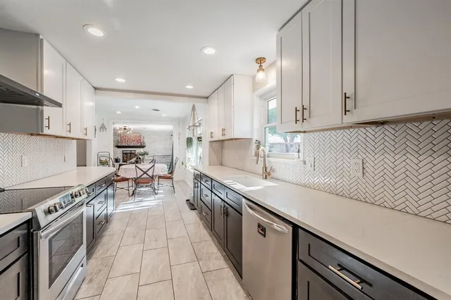 a kitchen with stainless steel appliances granite countertop a sink and cabinets
