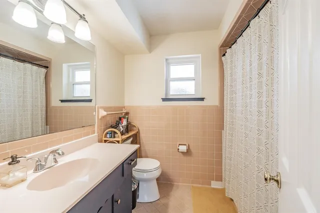 a bathroom with a sink a toilet and a mirror