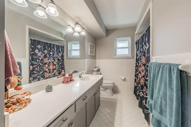 a bathroom with a sink a toilet and shower curtain