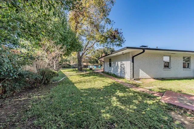 a backyard of a house with yard and tree
