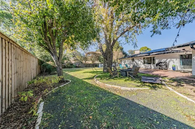 a view of a house with backyard and sitting area