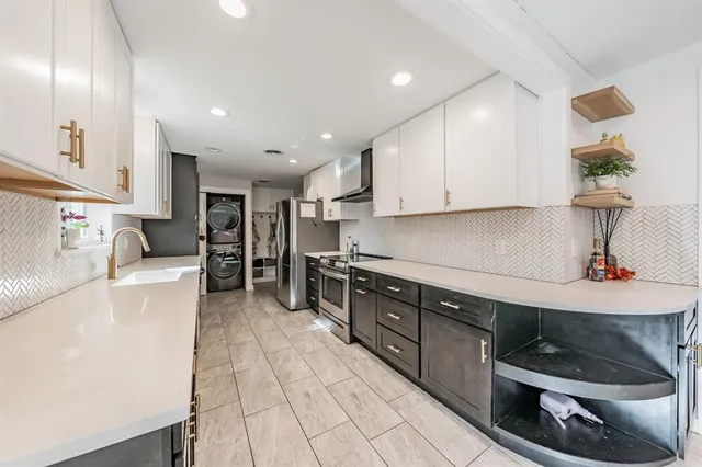 a kitchen with stainless steel appliances granite countertop a sink stove and cabinets
