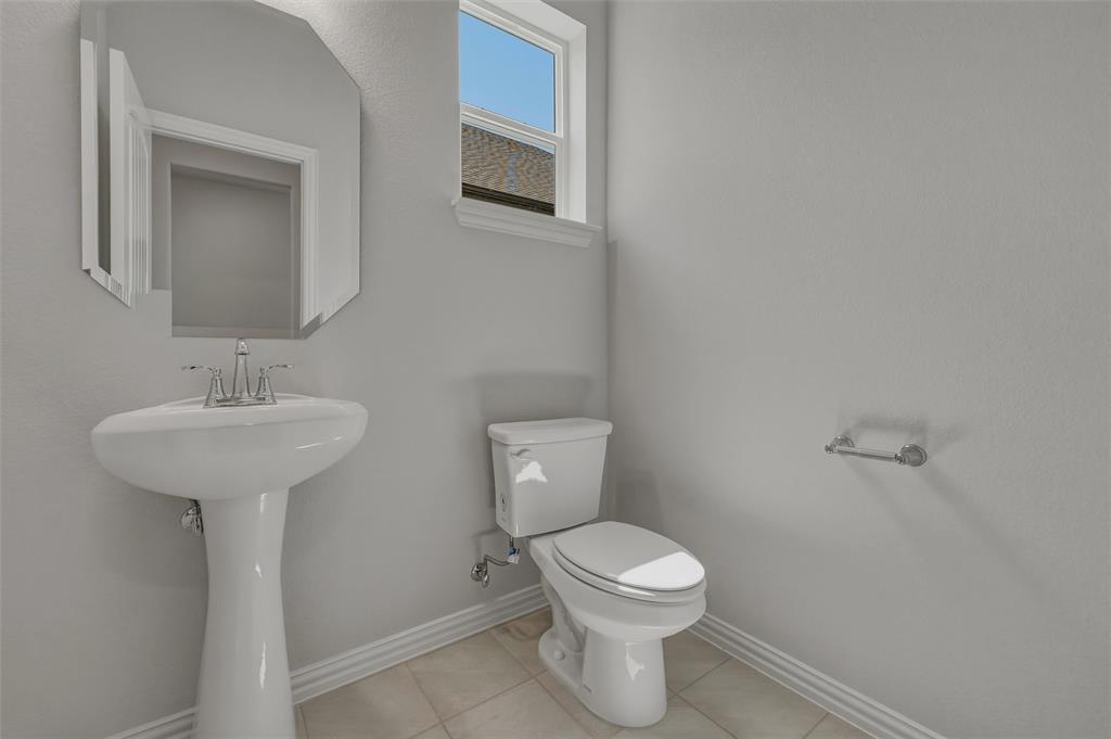 1337 Frio Drive Springtown, TX 76082 - Photo 26 of 40 Pedestal sink with chrome faucet, beveled mirror, window with natural light, and tile flooring
