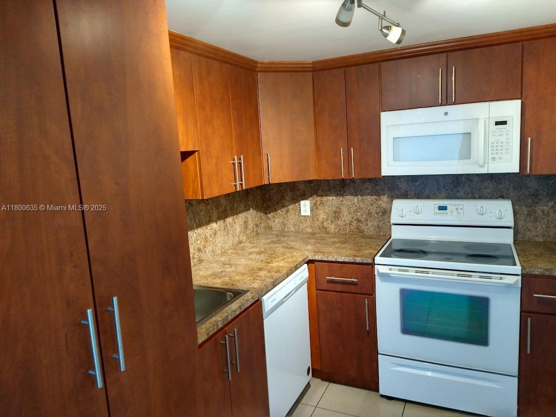 200 Southeast 15th Road, Unit 9B Miami, FL 33129 - Photo 20 of 39 a kitchen with granite countertop cabinets washer and dryer