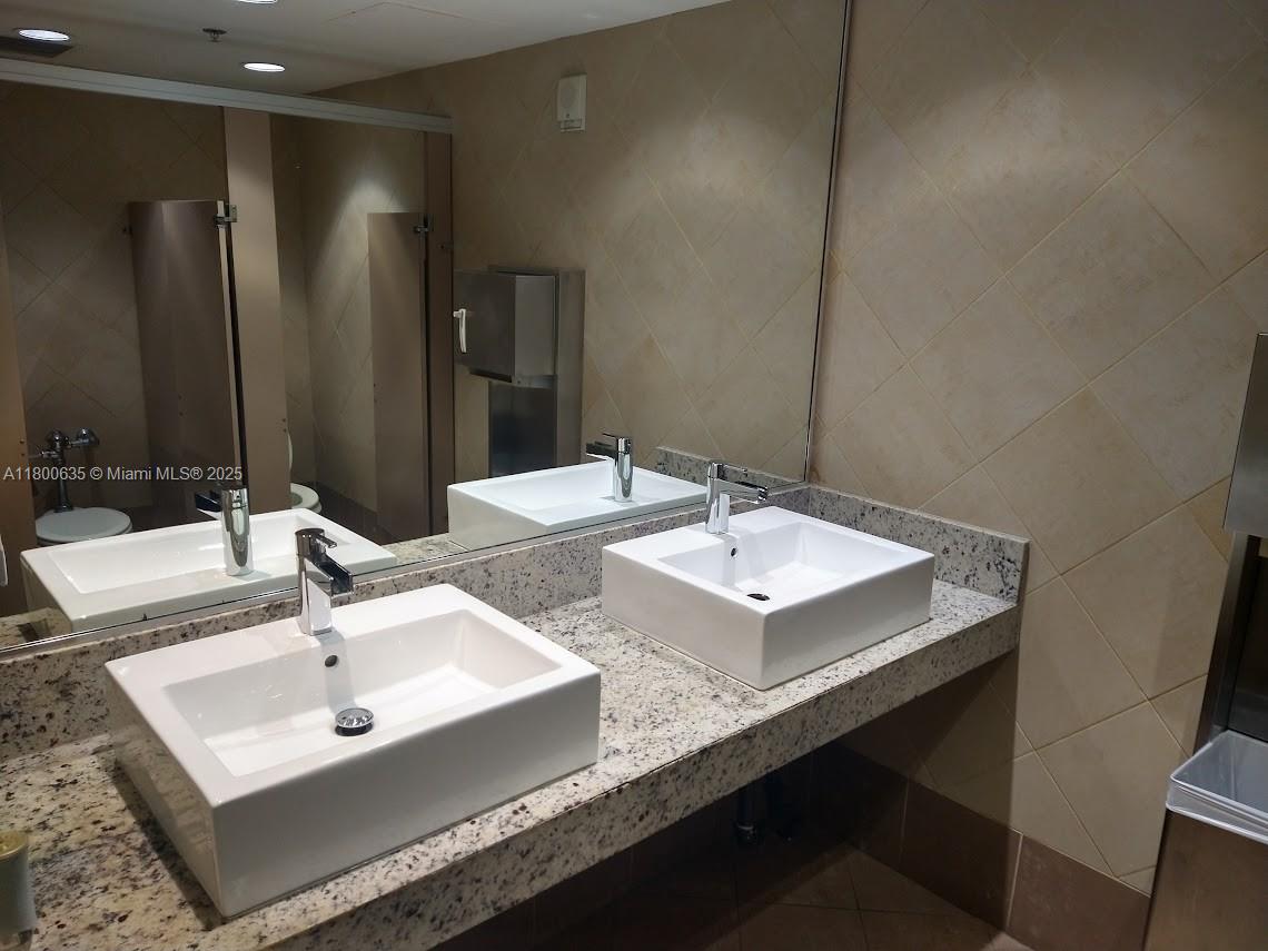 200 Southeast 15th Road, Unit 9B Miami, FL 33129 - Photo 38 of 39 a bathroom with double sink and a mirror