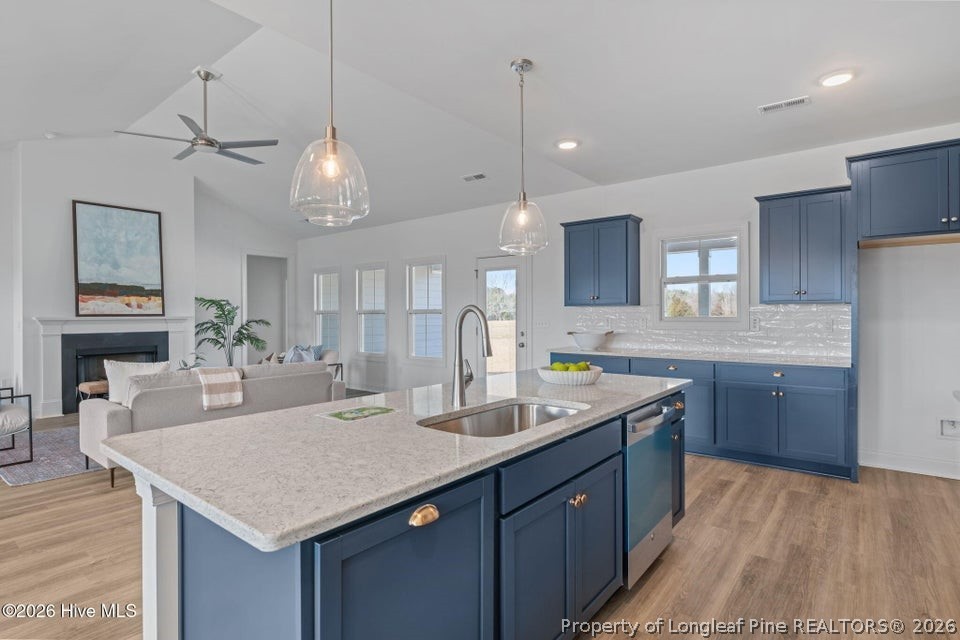 515 Sanctuary Trail Cameron, NC 28326 - Photo 25 of 46 a kitchen with a stove a sink a center island and a wooden cabinets