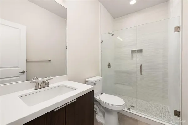 a bathroom with a sink a toilet and shower