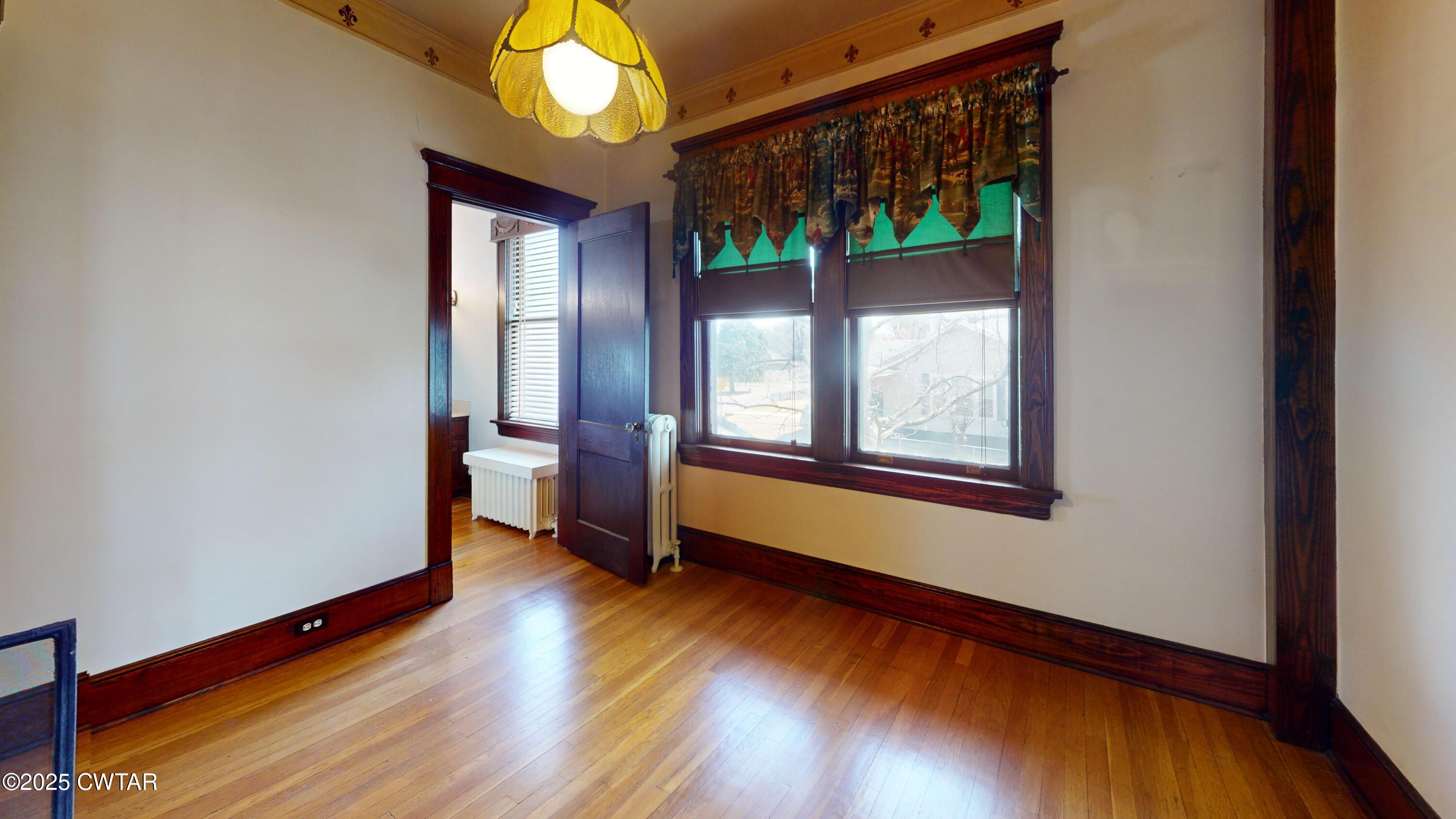 154 South Main Street Ripley, TN 38063 - Photo 20 of 40 a view of an empty room with wooden floor and a window