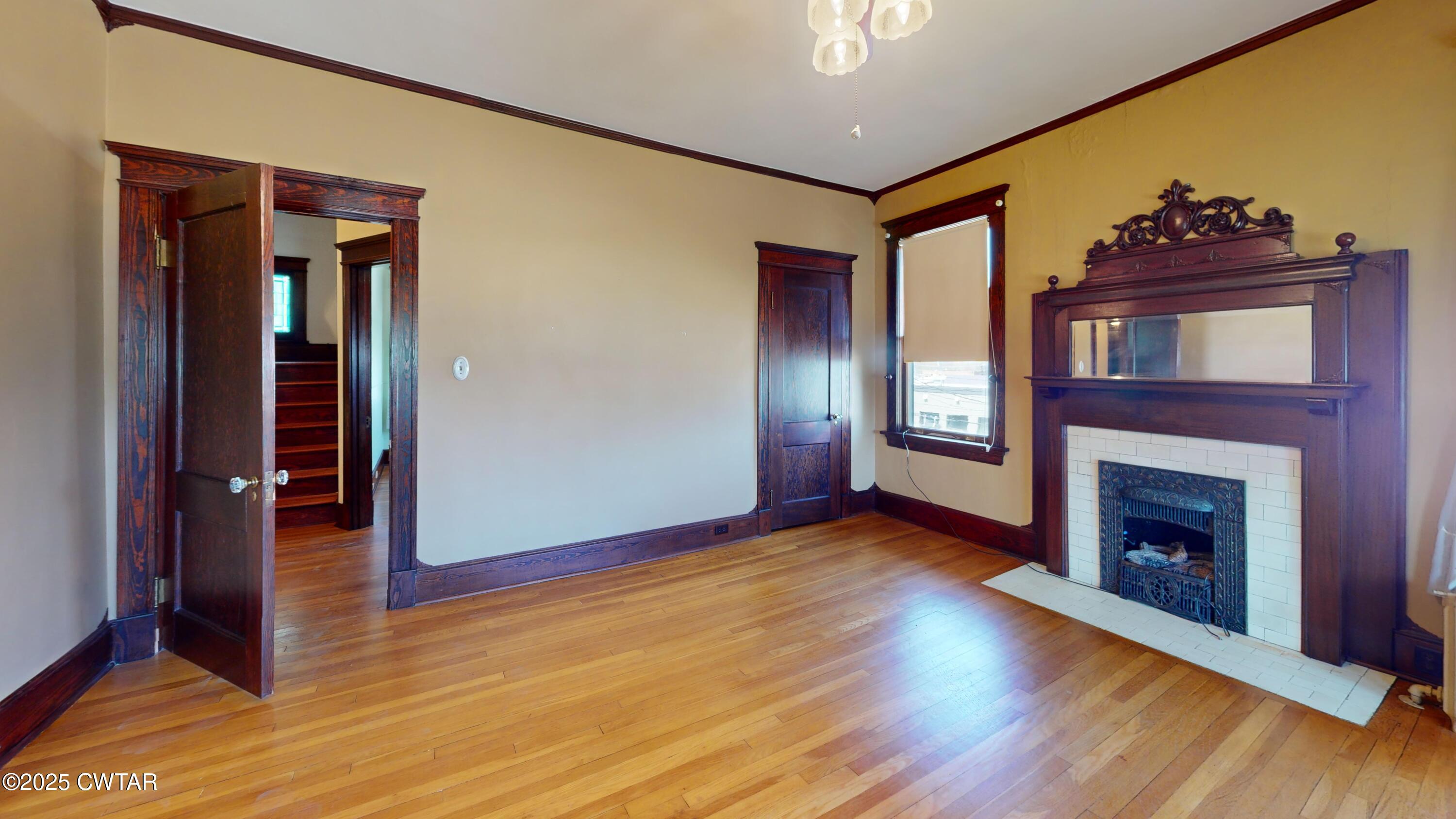 154 South Main Street Ripley, TN 38063 - Photo 24 of 40 a view of an empty room with wooden floor and a fireplace