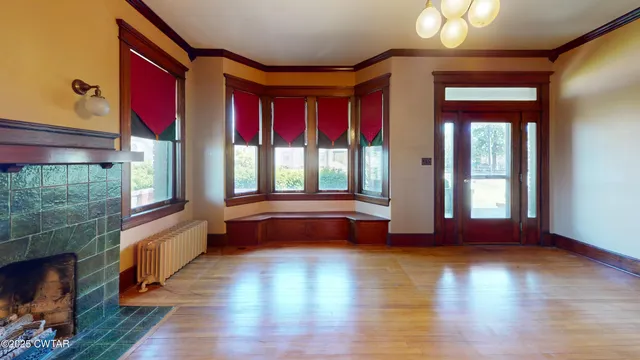 a view of front door with hallway and wooden floor