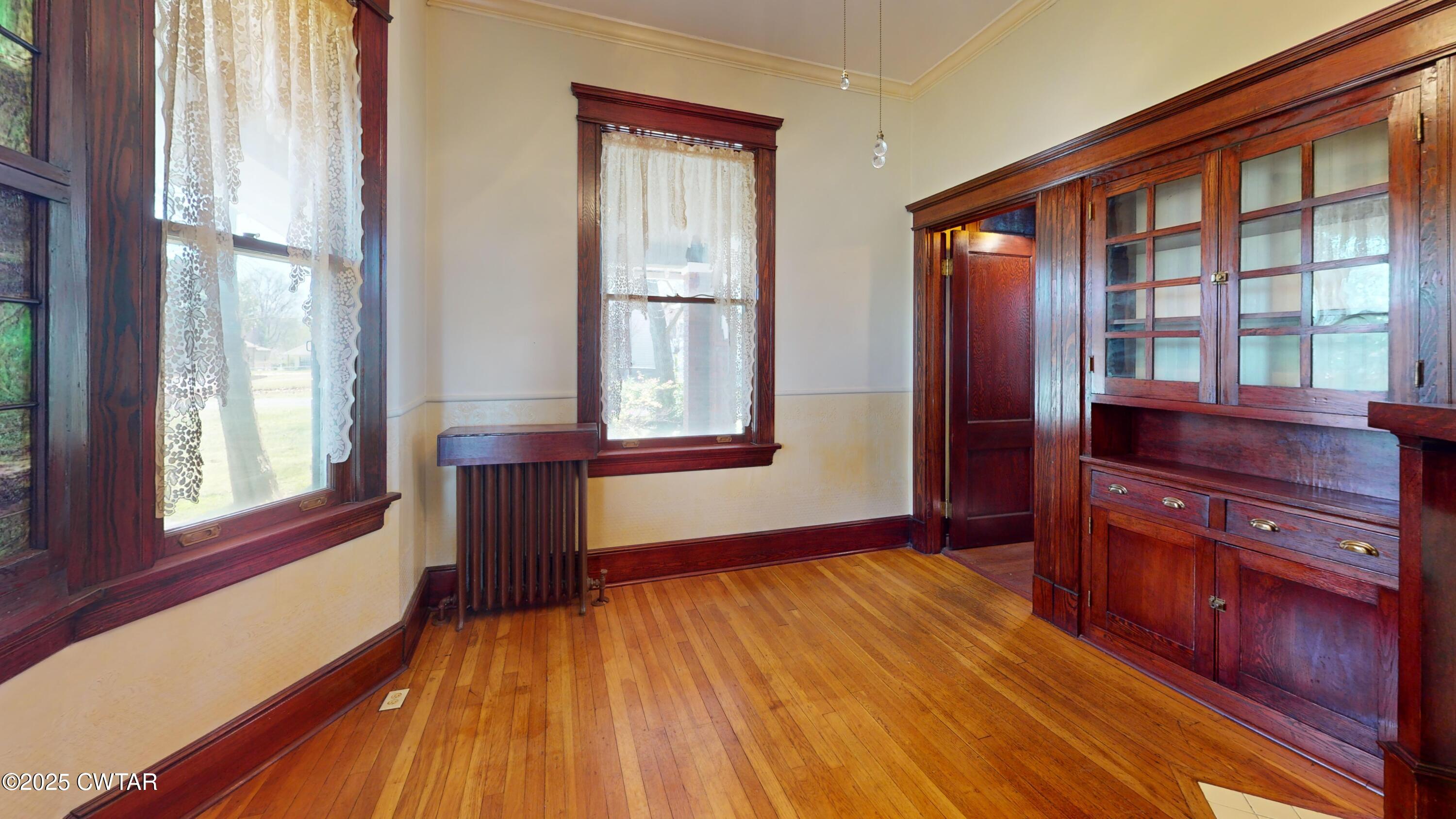 154 South Main Street Ripley, TN 38063 - Photo 9 of 40 a view of an empty room with wooden floor and a window