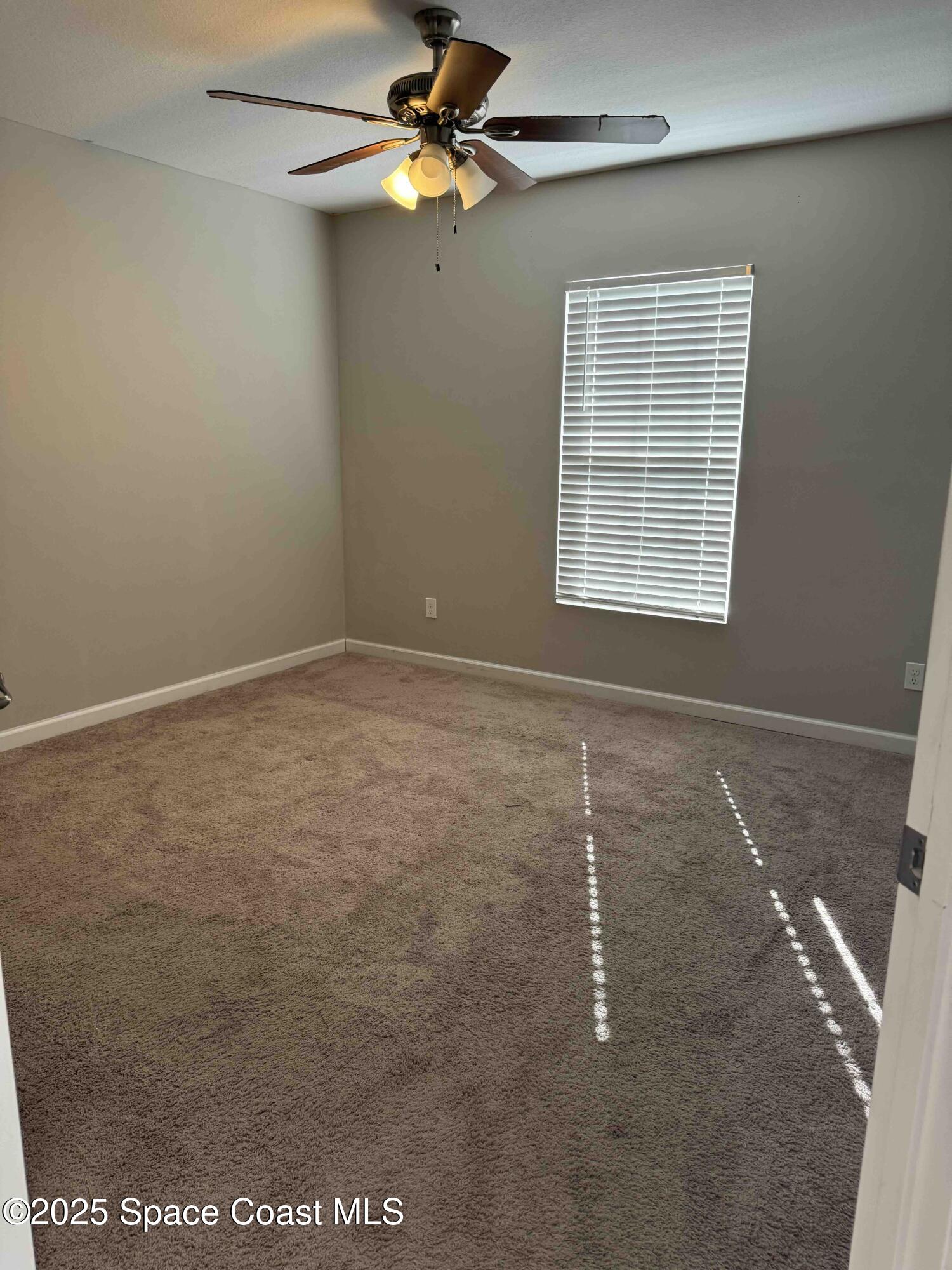 3925 Southwest Laffite Street Port St. Lucie, FL 34953 - Photo 6 of 20 an empty room with windows and fan