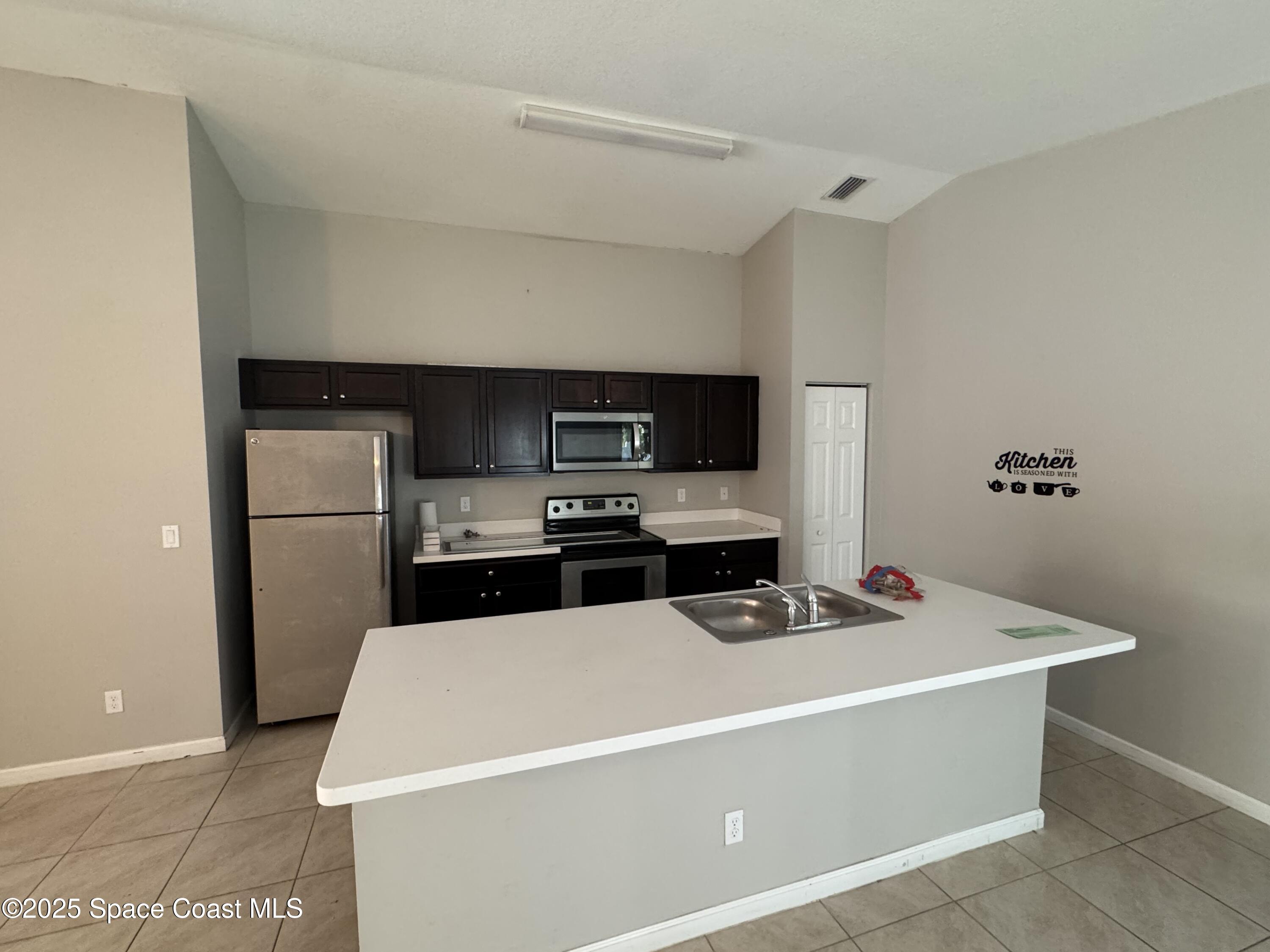 3925 Southwest Laffite Street Port St. Lucie, FL 34953 - Photo 9 of 20 a kitchen with a sink a stove and refrigerator
