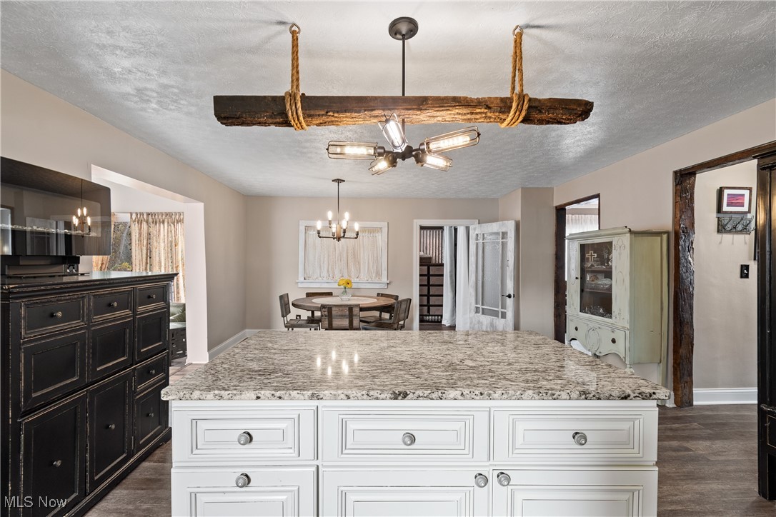 4786 Mayfair Road North Canton, OH 44720 - Photo 6 of 38 Kitchen with white cabinets, a chandelier, a textured ceiling, dark wood-style flooring, and a center island