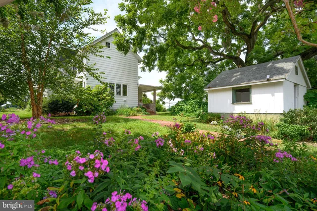 a view of a house with a big yard and potted plants
