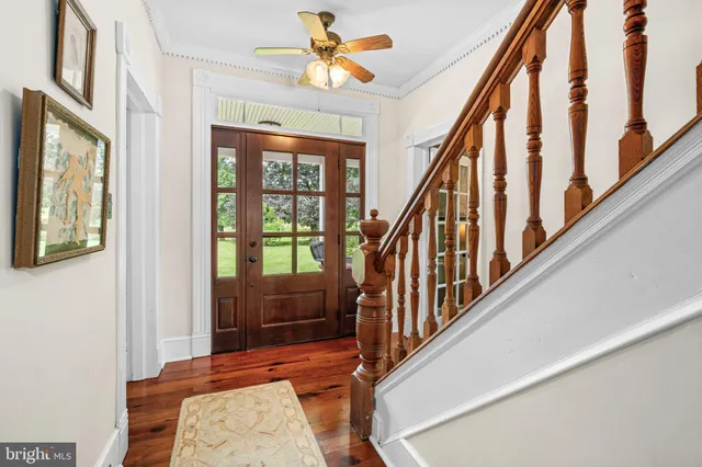 a view of a hallway with wooden floor and staircase