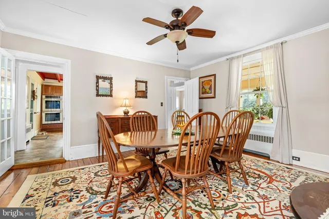 a view of a a dining room with furniture window and wooden floor