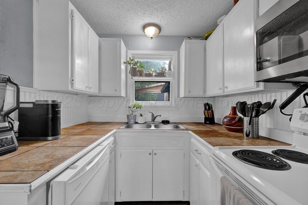4215 South Tyler Street Amarillo, TX 79110 - Photo 8 of 22 a kitchen with a sink a stove and cabinets