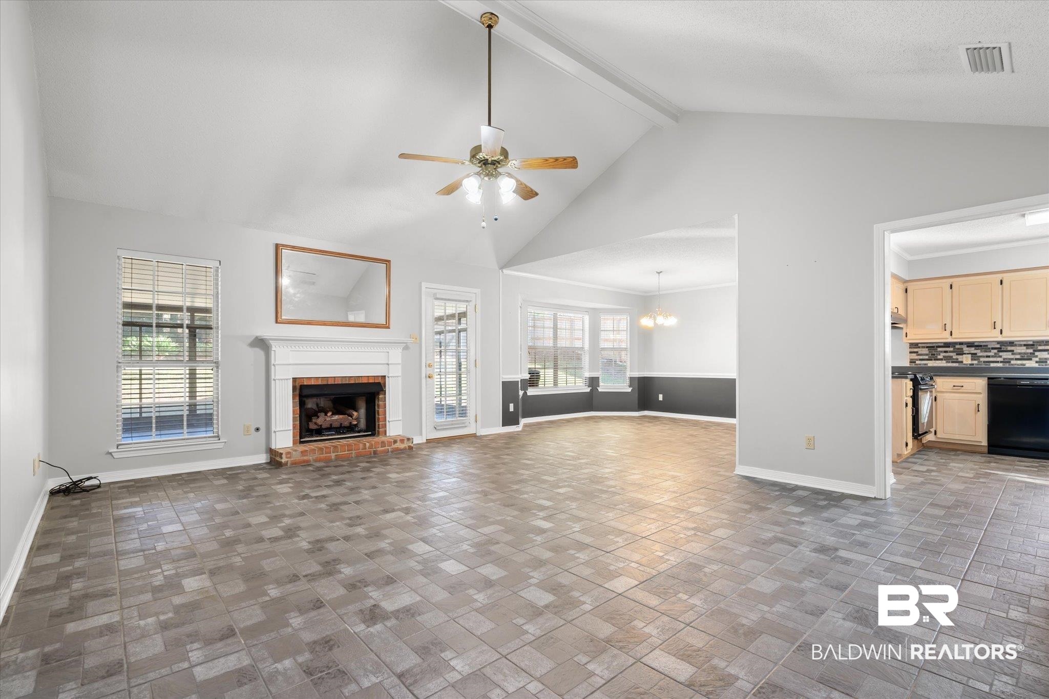 7410 East Lakeview Drive Mobile, AL 36695 - Photo 3 of 20 Unfurnished living room with a fireplace, ceiling fan with notable chandelier, high vaulted ceiling, and a healthy amount of sunlight