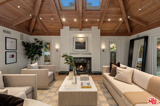 a living room with furniture a mirror and a chandelier